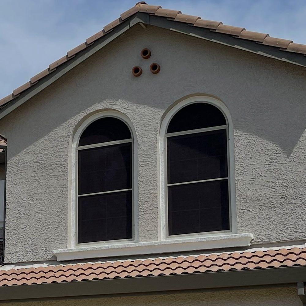 brown solar screens installed on arched windows improving heat protection and privacy
